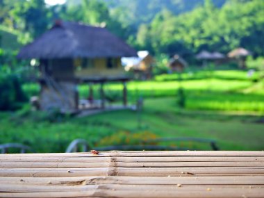 Bambu masa kenarı, arka planda Chiangmai, Tayland 'da bulanık kırsal tarım manzarası olan.