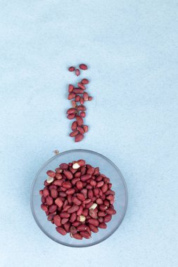 mavi arka plan üzerinde izole cam bir kase içinde fıstık, üst görünümü