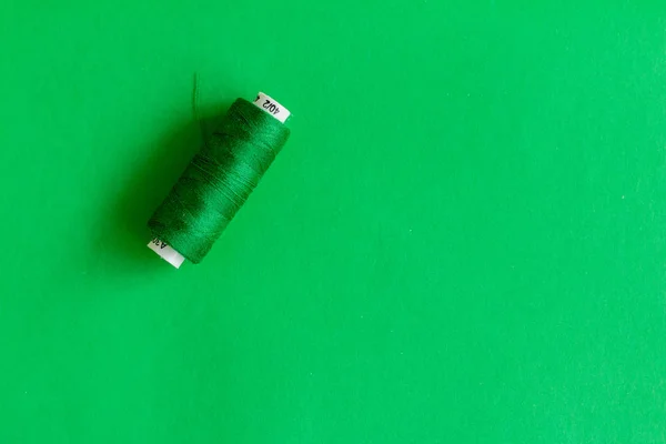 绿色线线在绿色背景上隔离的绿色线轴 缝纫事物的单色图片 — 图库照片