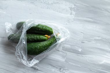 Taze salatalık plastik torbaiçine paketlenmiş, gıda düz metin, ekolojik kavram için yer ile yatıyordu