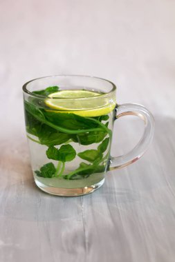 Bir cam fincan, taze, vitamin ve sağlık içeceği limon ve nane ile bitkisel çay