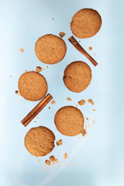 Kuru elma ve portakal dilimleri ve tarçın sopa ile Zencefil çerezleri mavi bir arka plan üzerinde uçuyor. Gıda levitation. Noel konsepti