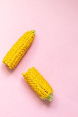 Tatlı çiğ mısır pembe arka plan üzerinde izole, metin için alan ile sağlıklı gıda resmi