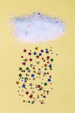 Renkli parlak yıldızlardan yağan yağmur bulutu, kart şablonu tasarımı sarı arkaplan ve metin için boşluk