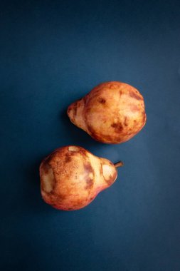 Olgun kırmızı armut, mavi armut karşısında. Sıfır atık ve organik gıda konsepti