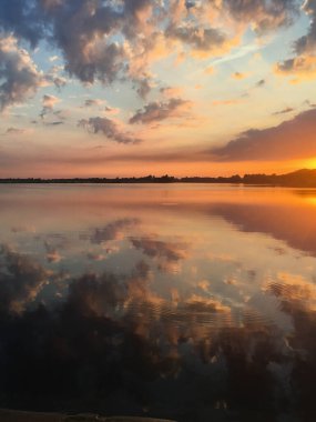 Güzel, parlak ve renkli yaz günbatımı yansıması bulutlarla