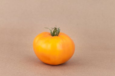 Bej arkaplanda izole edilmiş sarı büyük domates