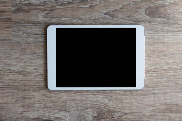 планшетный компьютер на деревянном фоне