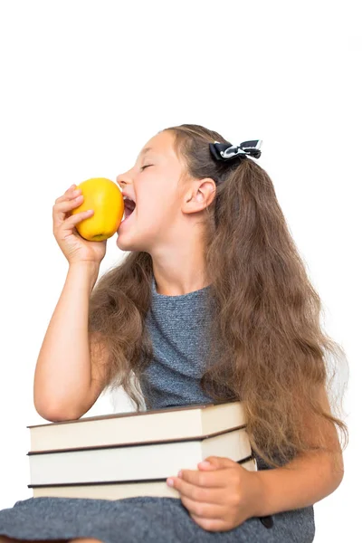 学校的孩子小学生吃苹果 有一堆书的学校女孩吃苹果水果 水果午餐 健康食品概念 学校的食物 在白色背景上被隔离 — 图库照片