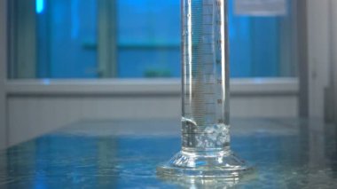 Şişeye su ile doldurun. Çözüm hacmi ölçmek. Bir ölçüm tselindre suya yakın çekim.