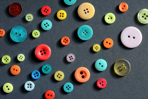 Isolated clothing colorful buttons on black background