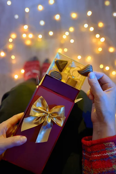 Frau Hält Schokoladengeschenk Neben Weihnachtsbeleuchtung — Stockfoto