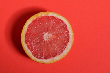 Kırmızı arka planda kırmızı greyfurt yarısı