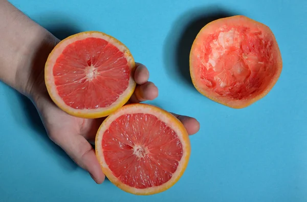 Fél Grapefruit Kezét Kék Háttér — Stock Fotó