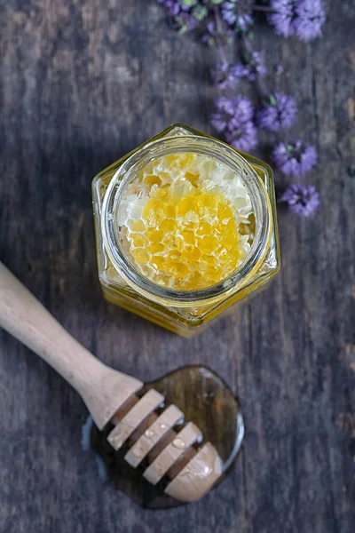 Favo de mel e mel em jarros — Fotografia de Stock