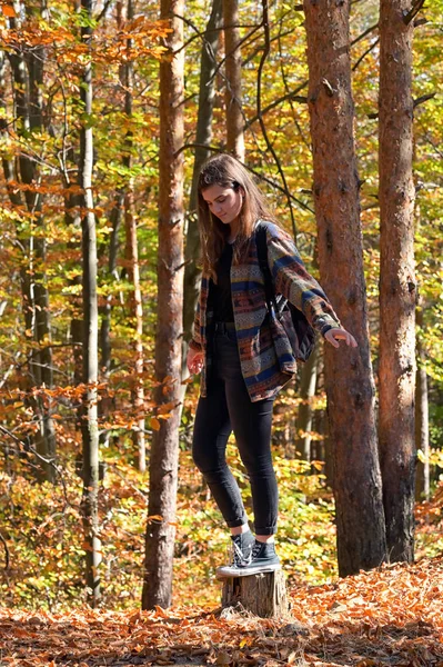 Uma jovem com uma mochila através do outono — Fotografia de Stock
