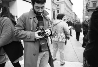 Vintage fotoğraf makinesi Rolleiflex adamla Hipster Close-up. Fotoğrafçı ile ünlü bir retro fotoğraf makinesi. Bologna, İtalya