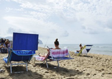 Kadınlar Dedikodu dergileri okuyarak sahilde rahatlatıcı.
