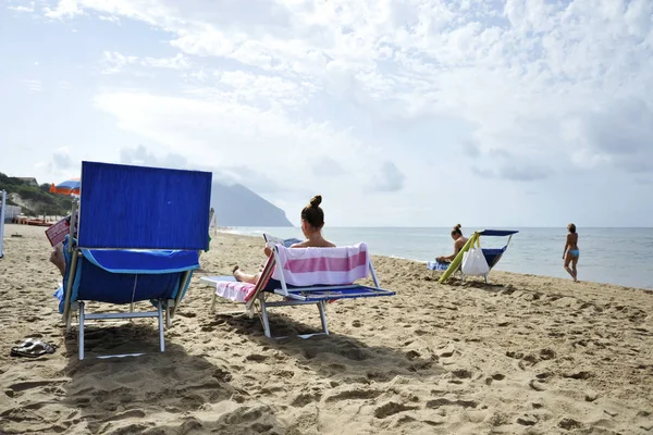 Kadınlar sahilde Dedikodu dergileri okuyarak rahatlatıcı. Sabaudia, Lazio, İtalya