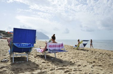 Kadınlar Dedikodu dergileri okuyarak sahilde rahatlatıcı.
