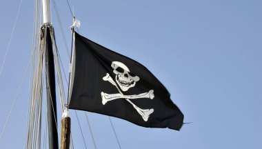 Korsanlar bayrak, mavi gökyüzü arka plan üzerinde sallayarak jolly roger
