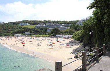 Tatilciler ve masmavi denizi ile Newquay plajda güneşlenenbirileri varsa. Newquay, Cornwall, İngiltere