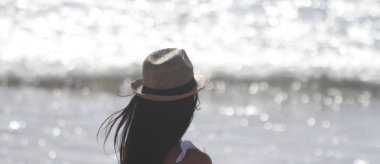 Güzel kız, arkadan, bak deniz şapka ile gördüm. Deniz içinde belgili tanımlık geçmiş. Sabaudia, Lazio, İtalya