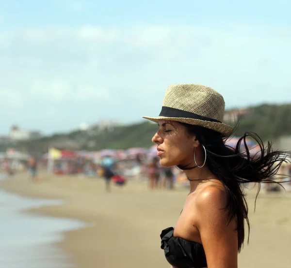 여자는 바람에 그녀의 머리와 그녀의 해변에 백그라운드에서 바다입니다 라치오 이탈리아 — 스톡 사진