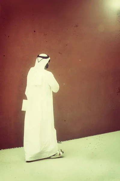 一个带着太阳镜和阿拉伯服装的优雅男子在他的国家的街道上走着 阿拉伯族裔概念 — 图库照片