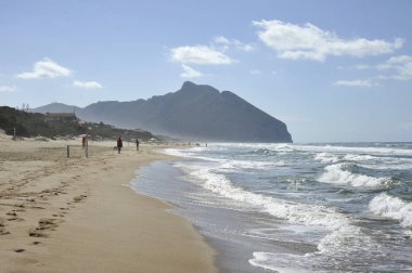 Bulutlu bir gökyüzü altında Shoreline, arka planda ünlü Circeo dağ, Lazio, İtalya.