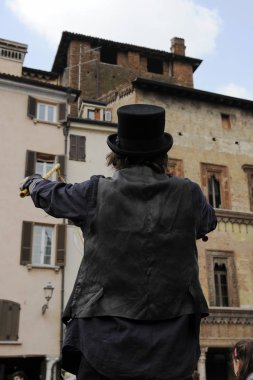 Sabun köpüğü yapan siyah şapkalı bir erkek sanatçı. Sokakta sabun köpüğü gösterisi.