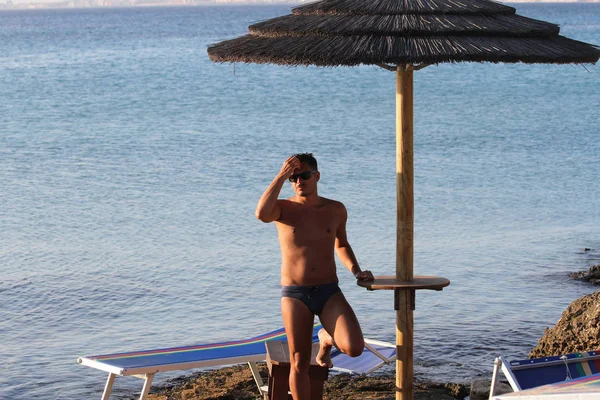 Stilig Man Med Solglasögon Och Baddräkt Njuter Stranden Vid Solnedgången — Stockfoto