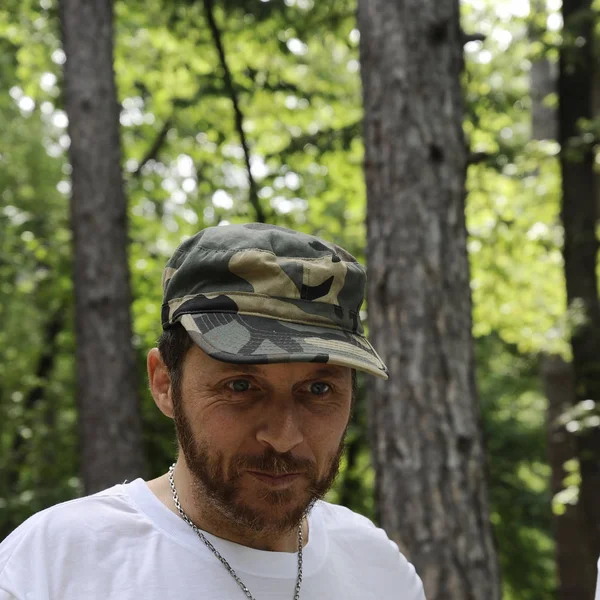 Outdoors horizontal portrait of happy hiker young man with red beard, feel good after hiking in forest. Traveler bearded male smiling and feel happy during trekking in his journey. Travel, lifestyle