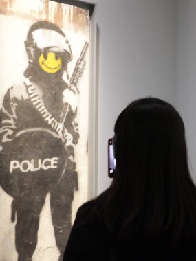 Ziyaretçiler, Banksy 'nin izinsiz sergisinde fotoğraf çekiyor.
