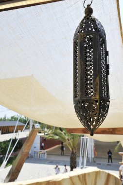 Tipik bir Arap lambası asılı. Arka planda güneş çadırı. Güneşli bir gün.