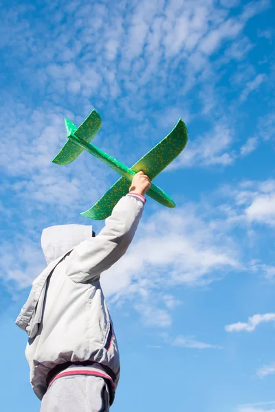 Young boy playing with toy airplane play in the sky