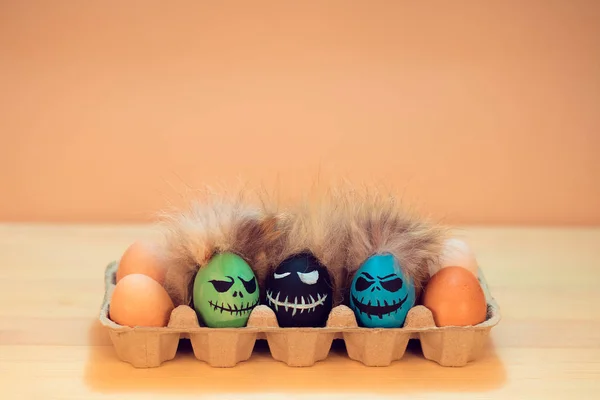 Colorful eggs with funny, scary faces. The concept of the holiday of Halloween