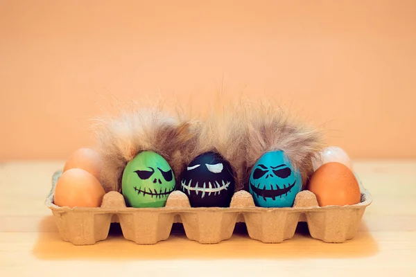Evil faces on eggs with hair in brown paper box