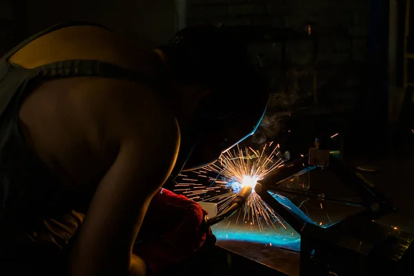 Welder in the mask works welding. Welding sparks.