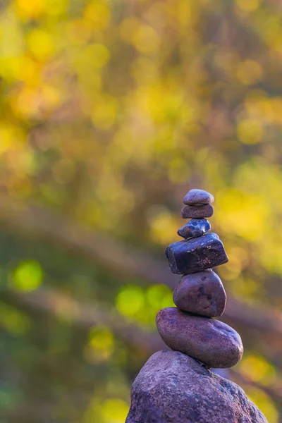 Pyramide en pierre empilée devant fond vert flou avec bokeh — Photo