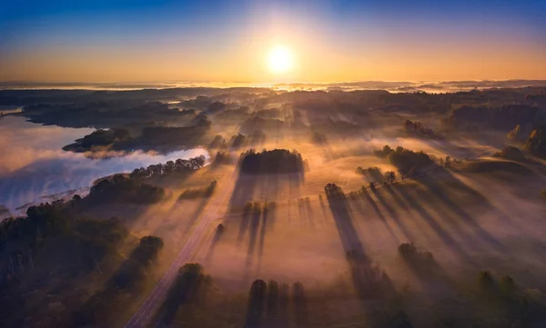 Воздушный обзор эпических световых лучей над полями осенью — стоковое фото