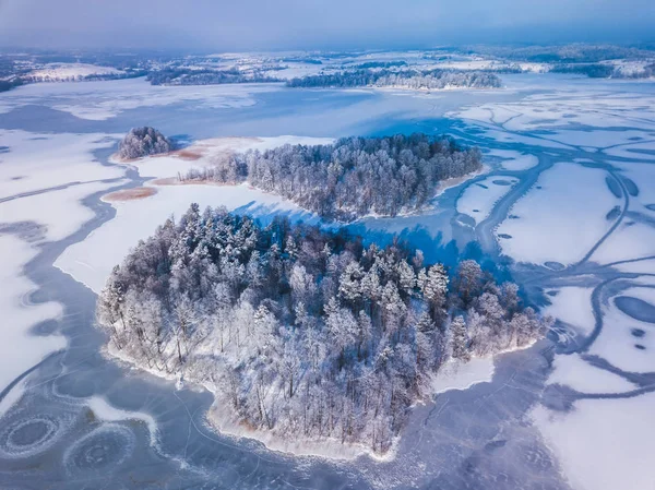 Flygfoto över vintern snön täckte skog och frusen sjö från ovan tagits med en drönare i Litauen. — Stockfoto