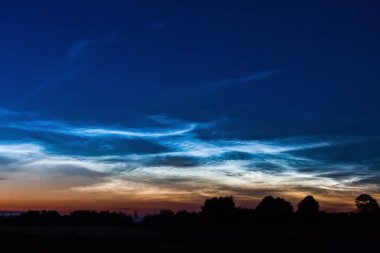 Noctilucent koyu mavi bulutlar güzel gökyüzü ile Horizon olarak hızlı hareket eden. Simli bulutlar Noctilucent bulutlar, nadir gökyüzü fenomeni noctilucent bulutların üstünde yıldızlar arka plan, hızlandırılmış.