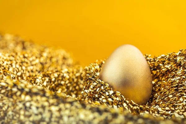 Εικόνα του λαμπερό χρυσό αυγό σε χρυσό ύφασμα — Φωτογραφία Αρχείου