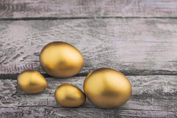 Υπόβαθρο του χρυσά αυγά σε μια ξύλινη επιφάνεια — Φωτογραφία Αρχείου