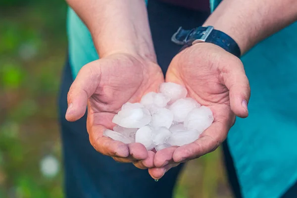 Mann hält Hagel nach Hagelschlag in der Hand — Stockfoto