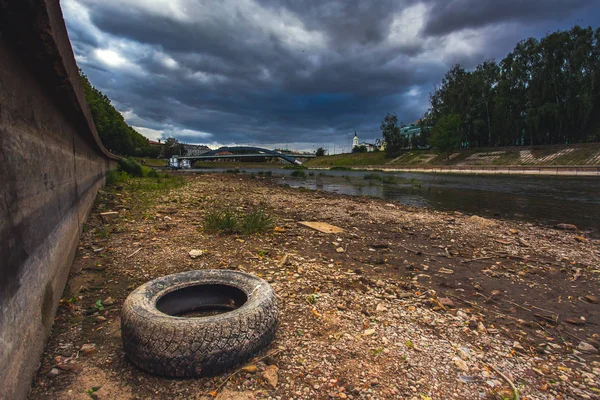 Světový problém s globálním oteplováním, řeka Dricks Neris se starým kolečkem na drané zemi ve Vilniusu, Litva — Stock fotografie