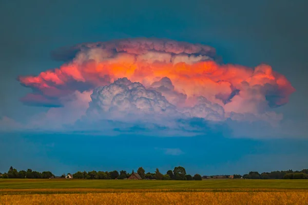 Schweres Pulsgewitter Kumulonimbuswolken beleuchtet von abends rotem Licht, ein seltener Moment — Stockfoto