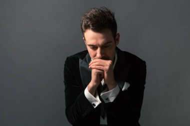 Yukarı aşağı, düz studio arka planı arıyorum genç yakışıklı biri ceketimi, kravat ve gömlek düğmeleri yapılmadıkları portresi kapatın