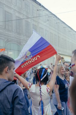 Moskova/Rusya - 1 Temmuz 2018: Kız waveing FIFA Dünya Kupası, Rusya'nın Moskova Nikolskaya sokakta yürüyen Rus Milli Takımı'nın zaferini kutluyor ise Rus bayrağı